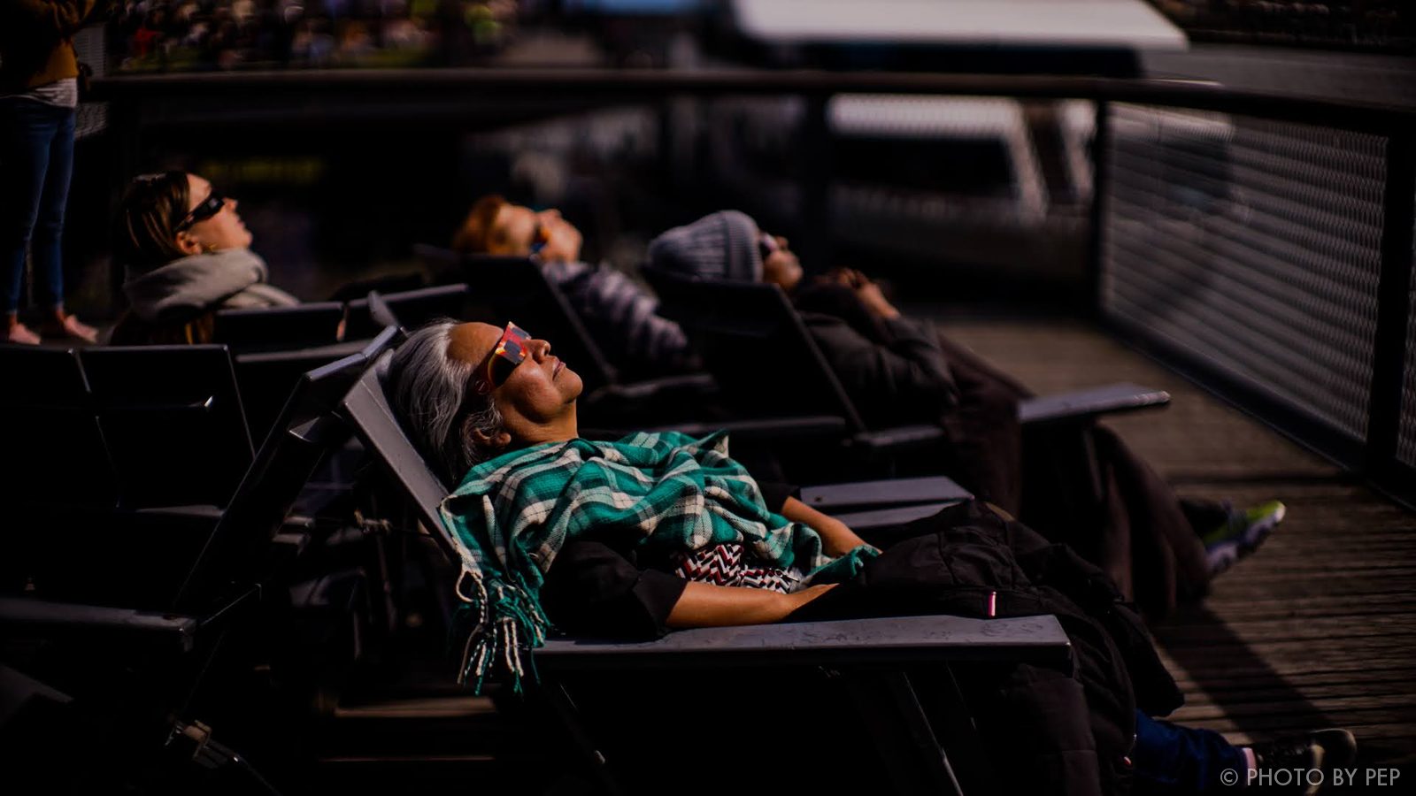 Eclipse viewers reclining on a deck, looking skyward